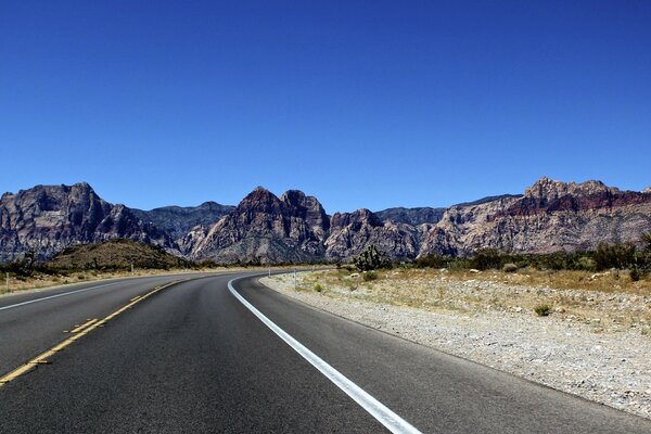 The road to the mountains under the blue sky