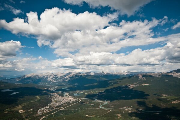 Landscape of the green valley from the height of the snow-capped mountains