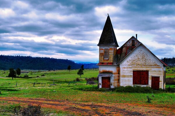 Uma velha casa abandonada com uma torre no deserto de rovnina