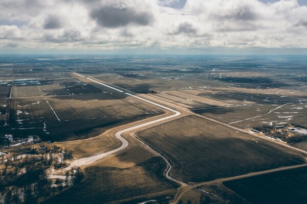 Blick auf den Boden mit Straßen und Feldern aus dem Flugzeug