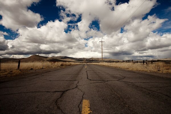 Carretera solitaria abandonada entre campos secos