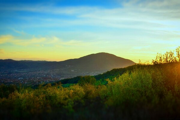 Sonnenuntergang zwischen Bergen und Wäldern