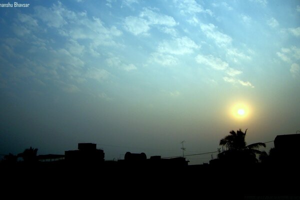 Soleil couchant sur les silhouettes des maisons