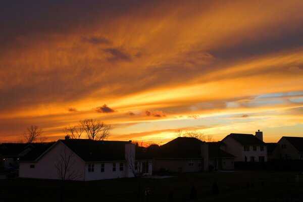 Coucher de soleil sur tout le ciel sur fond de maisons