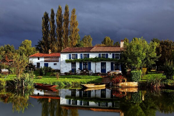 Two-storey house on the lake surrounded by trees