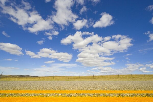 Campo, strada e nuvole bianche