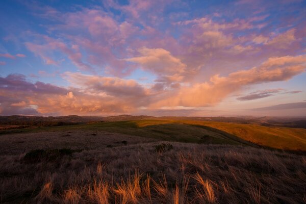 Hermosa puesta de sol en la naturaleza. Amplio campo al atardecer