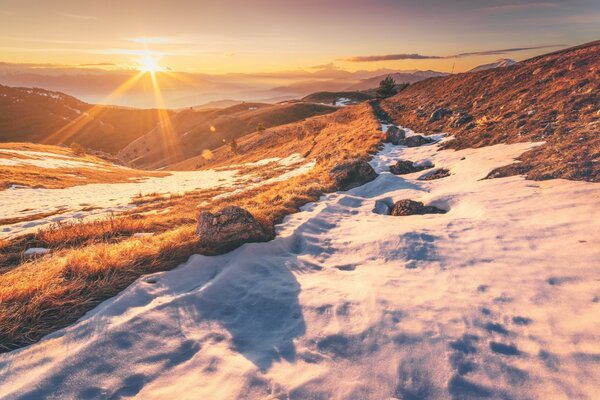 Soleil levant dans les montagnes enneigées