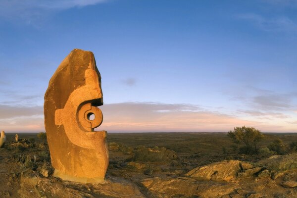 Landscape in the desert with an ancient sculpture