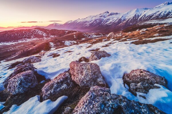 Strada rocciosa innevata in montagna