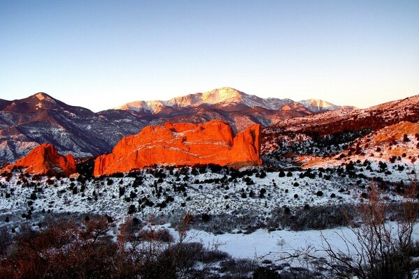 Snow-covered red sunny mountains