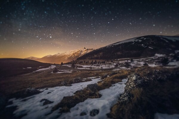 Starry night sky over the mountains in winter