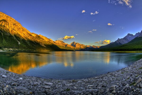 Lago de montaña, agua clara y costa rocosa