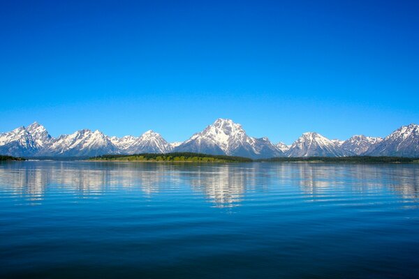 Reflet des montagnes enneigées dans la surface de l eau