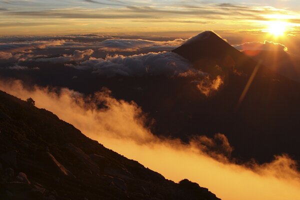 El sol naciente sobre las nubes en las montañas