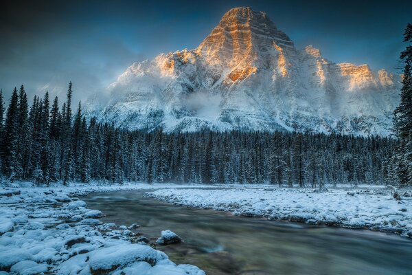 Winterlandschaft. Ein Fluss, der von Dunkelheit bedeckt ist