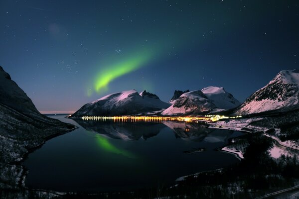 La mágica Aurora boreal sobre la bahía y las montañas