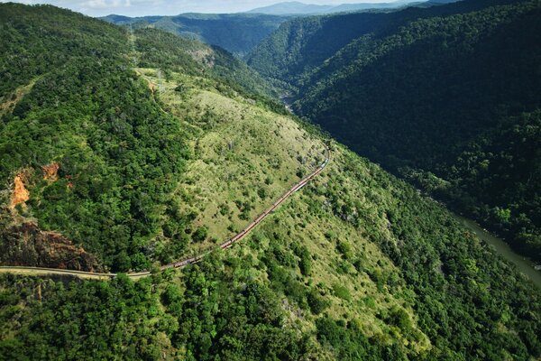 Route traversant de hautes collines verdoyantes