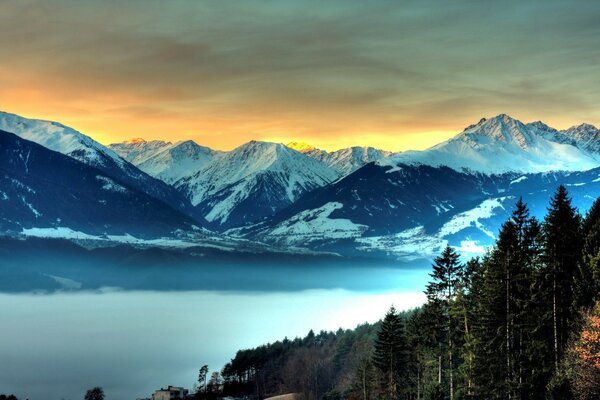 Schneebedeckte Berge und Nebel gefüllt Tal