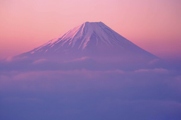 A high mountain protrudes through the clouds