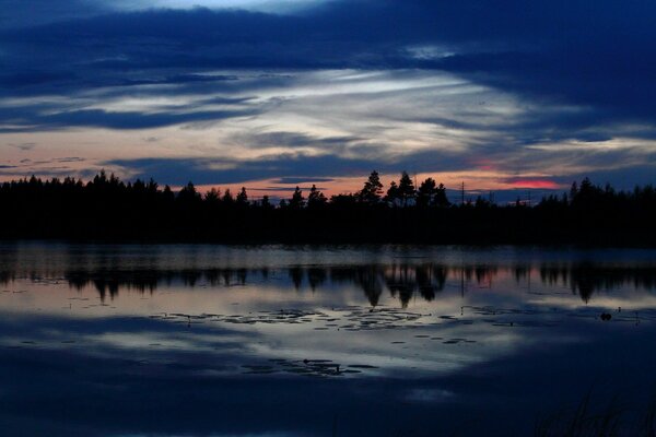 Dark sunset on the shore of a quiet lake