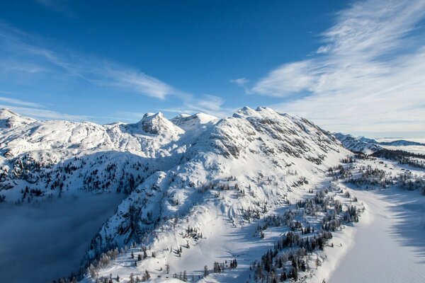 Berggipfel im Schnee vor dem Hintergrund des blauen Himmels