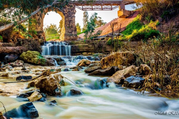 Bridge over the rapid flow of a river waterfall