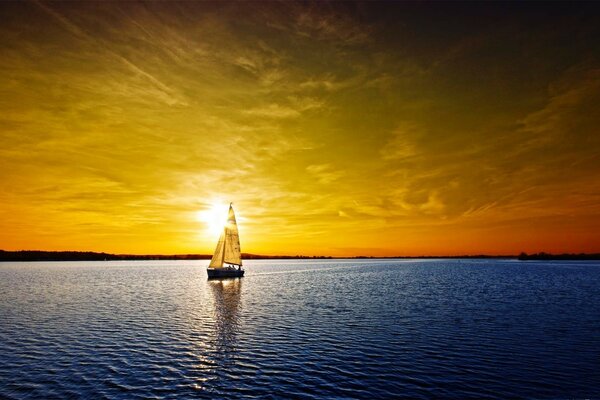 A ship sailing on the sea into the sunset