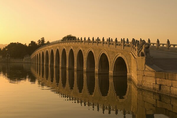 Architektonische alte Brücke am ruhigen Fluss