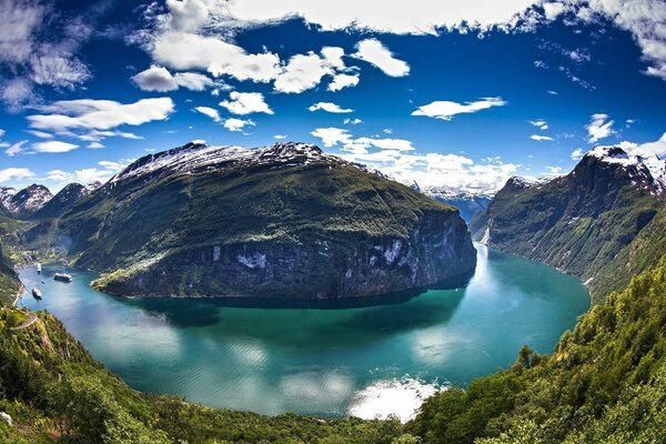 El lago rodea la montaña verde