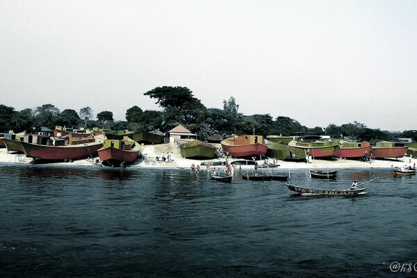 Rangée de grands bateaux le long de la rivière