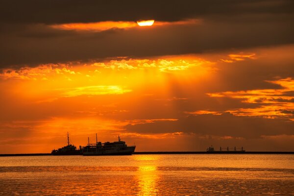 Sonnenuntergang am Meer über Schiffen