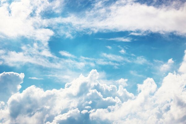 Flaumige Wolken am blauen Himmelshintergrund