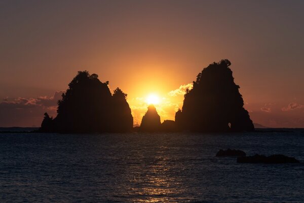 Puesta de sol sobre la isla en el mar