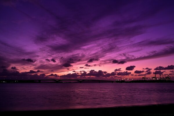 Schöner Sonnenuntergang über dem Wasser in einem violetten Farbton