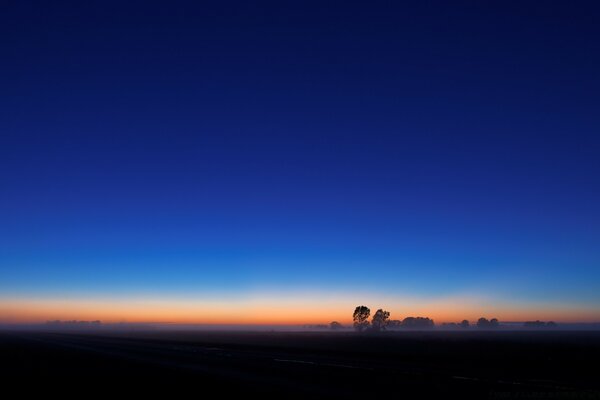 Sky horizon with sunset and dark field