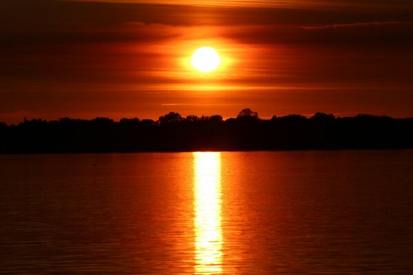 The red sunset is reflected on the water