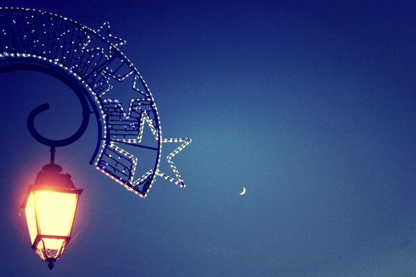 A small lantern shines back at the crescent moon