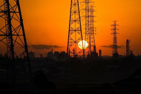 Elektrische Türme vor dem Hintergrund der untergehenden Sonne