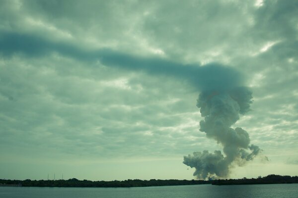 Smoke on the horizon connects with clouds