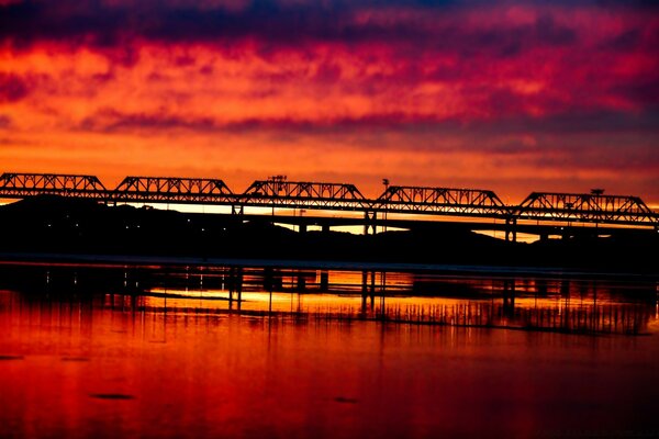 Nel riflesso dell acqua, il ponte è visibile sullo sfondo del tramonto