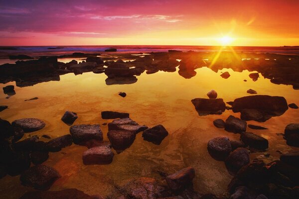 El sol brillante que sale al mar