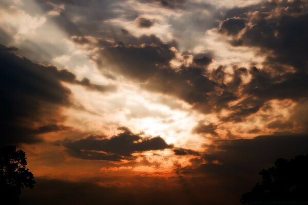 Evening sky with a silhouette of clouds against the background of the setting sun