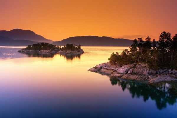 Rocky islets in the sea on the background of sunset