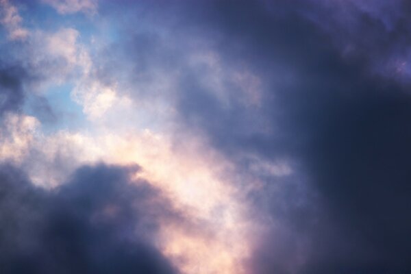 Die Sonne versucht, wegen der dunklen violetten Wolken herauszukommen