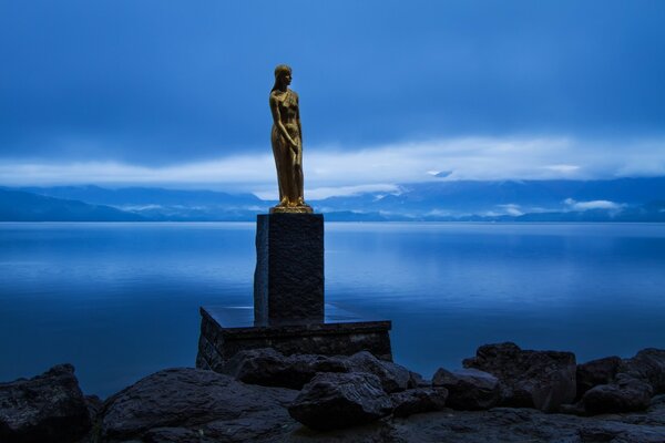 Статуя на тлі синьої води і неба