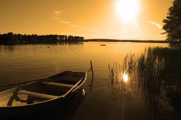 Boat in the lake on the background of sunset