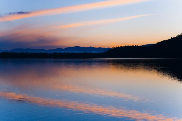 Reflection of the dawn in the lake on the background