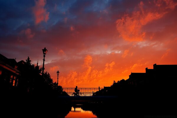 Silhouette of a cyclist against the sunset sky