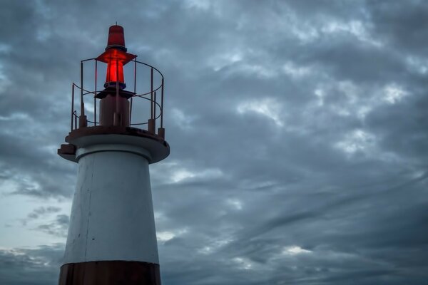 Einsamer Leuchtturm, der im bewölkten Himmel steht